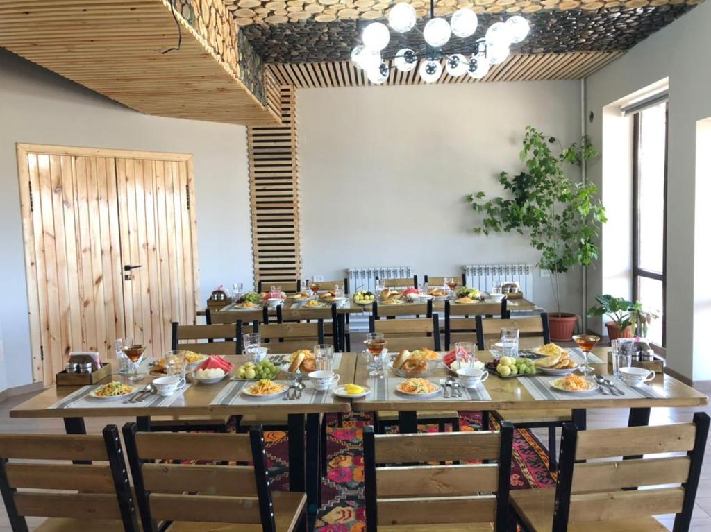 uma grande sala de jantar com uma grande mesa com cadeiras em Kezgin Guest House em Naryn