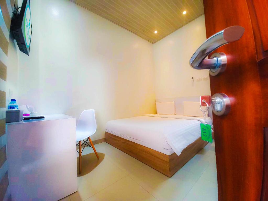 Cette petite chambre comprend un lit et un bureau. dans l'établissement Hometown Residence, à Bandar Lampung