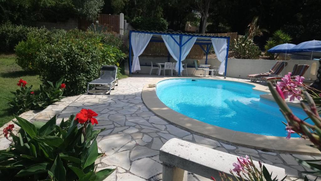 a swimming pool in a yard with flowers at Le mazet in La Londe-les-Maures