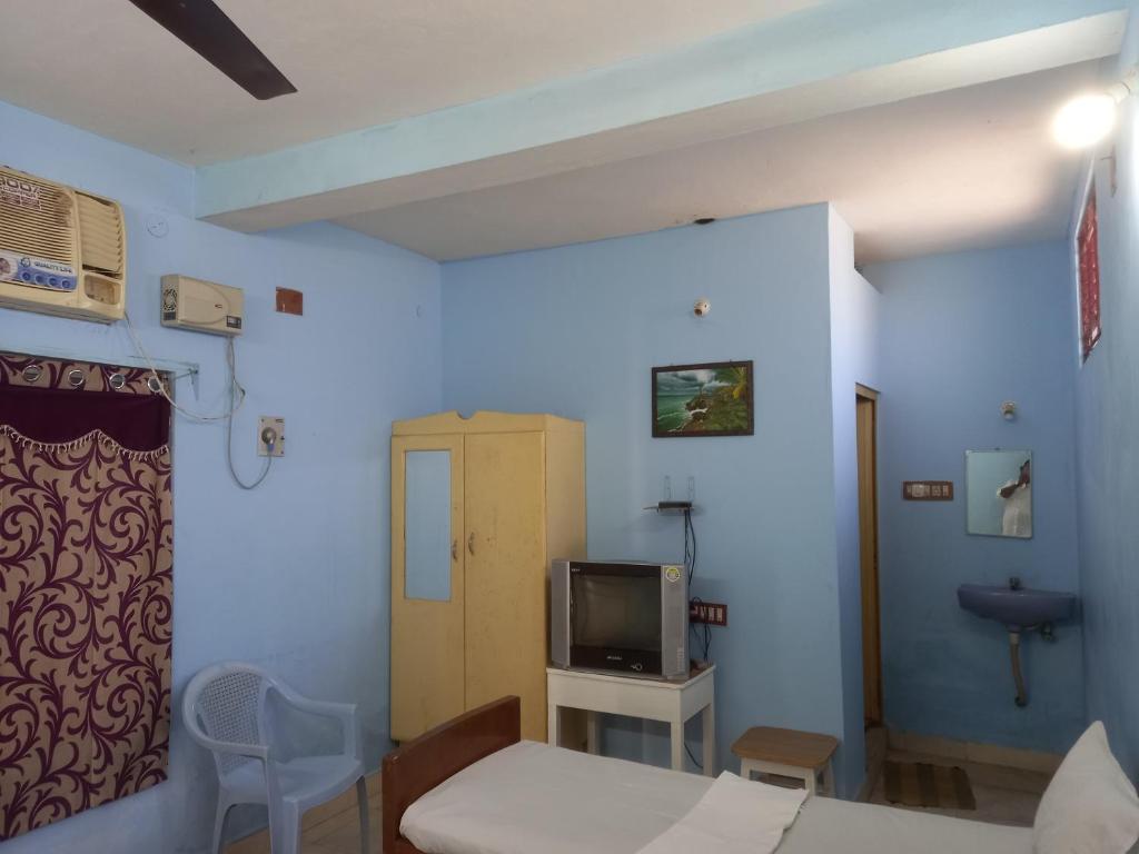 a hospital room with a bed and a tv at Parisha Residency- Temple Side Hotel in Chidambaram