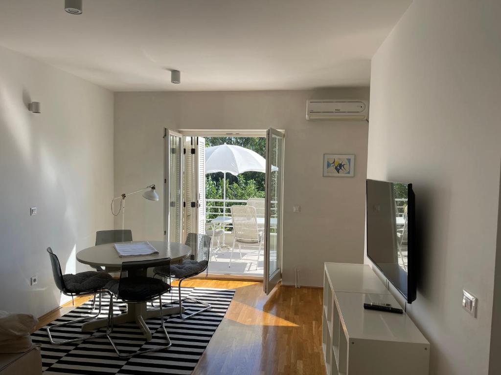 salon ze stołem, krzesłami i parasolem w obiekcie Apartments Mali Ivo w Nin