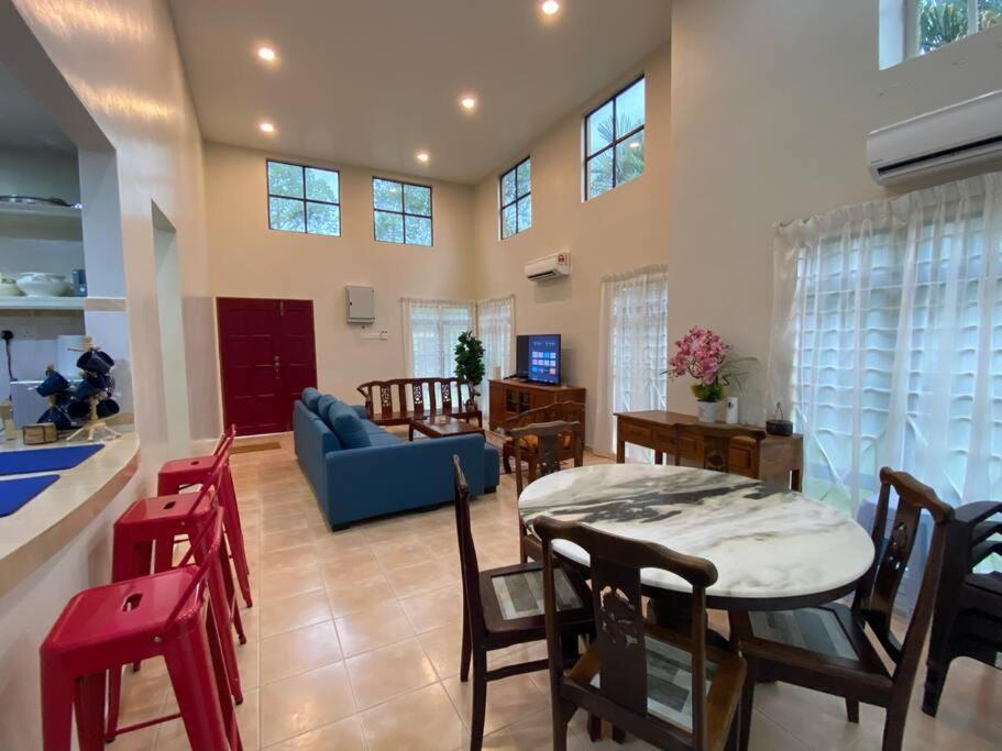 un soggiorno con divano blu e tavolo di Villa Teratai 878 @ A'Famosa Resort a Kampong Alor Gajah