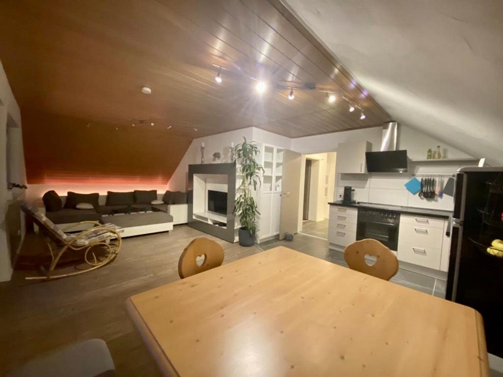 eine Küche und ein Wohnzimmer mit einem Tisch und einem Sofa in der Unterkunft Ferienwohnung mit Ausblick in Mömbris
