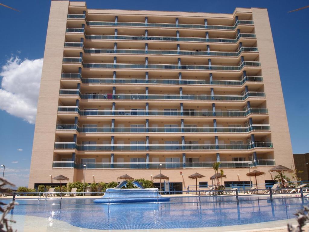 a large building with a swimming pool in front of it at Apartamentos Europa House Sun Beach in Guardamar del Segura