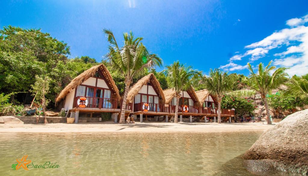 um grupo de cabanas numa praia perto da água em Sao Biển Cam Ranh - Starfish Cam Ranh em Cam Ranh