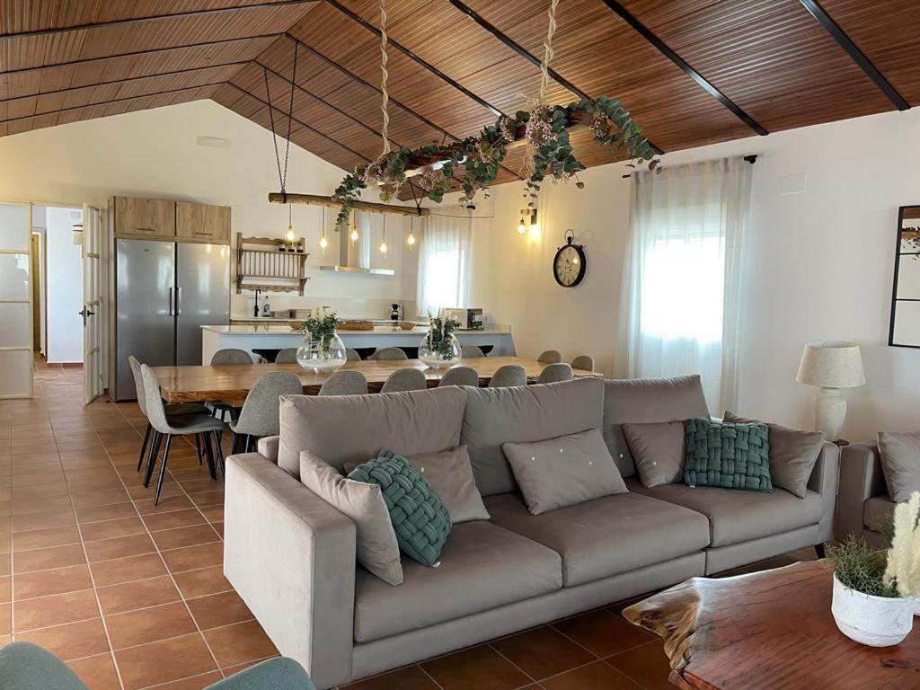 a living room with a couch and a table and a kitchen at Casa rural La Alcaparra in Écija