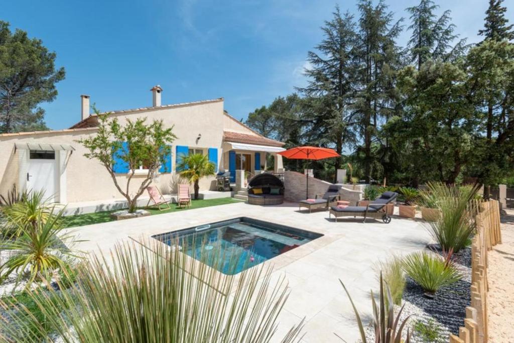 une cour arrière avec une piscine et une maison dans l'établissement La Dolce Villa avec piscine chauffée & cigales, à Poulx