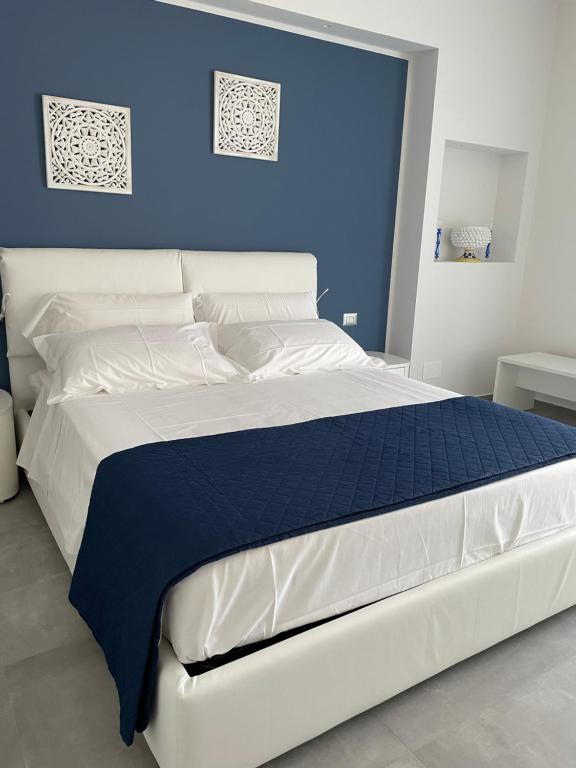 1 cama blanca grande con pared azul en Luxury Sea House, en Trapani