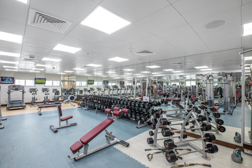 a gym with a large room filled with lots of machines at City Premiere Hotel Apartments - Dubai in Dubai