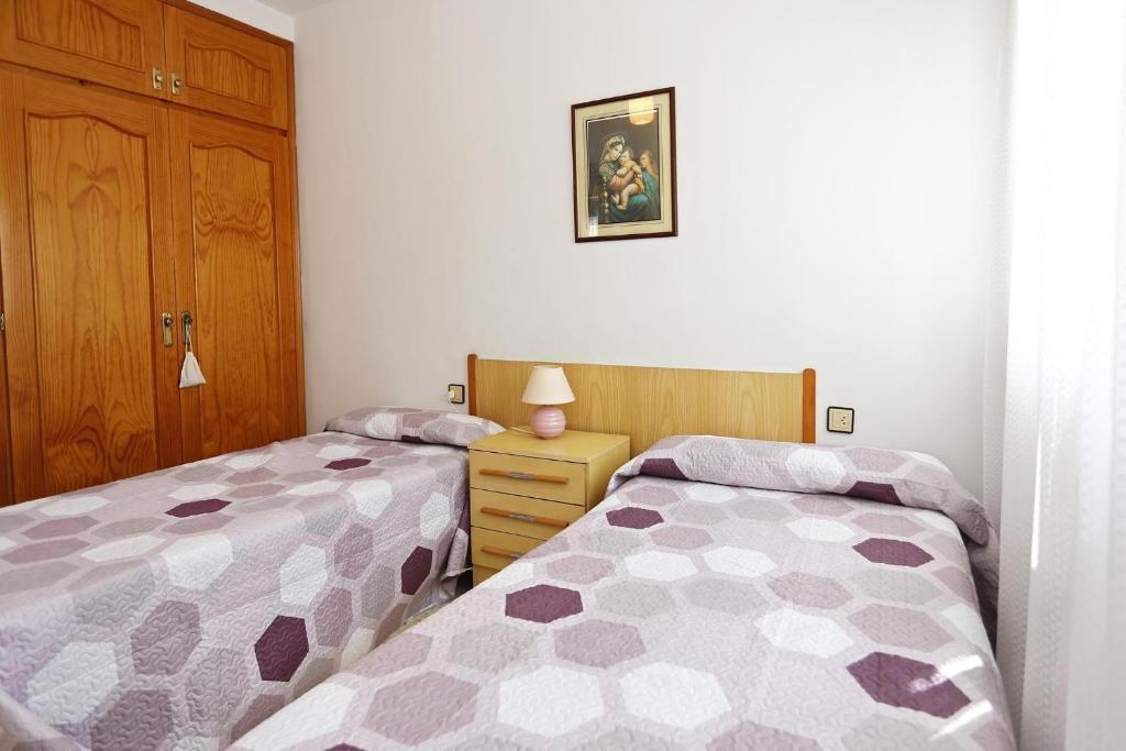 A bed or beds in a room at AT096 Piscina privada, barbacoa, wifi, 900m de la playa