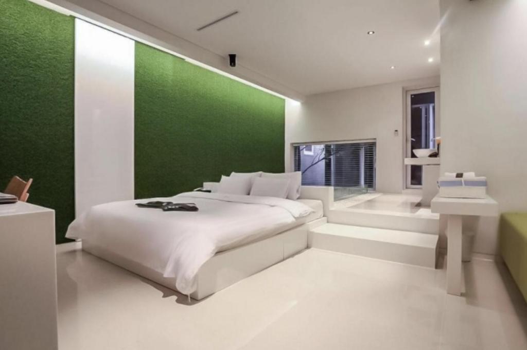 a bedroom with a green wall and a bed at Nine Star Hotel in Seoul