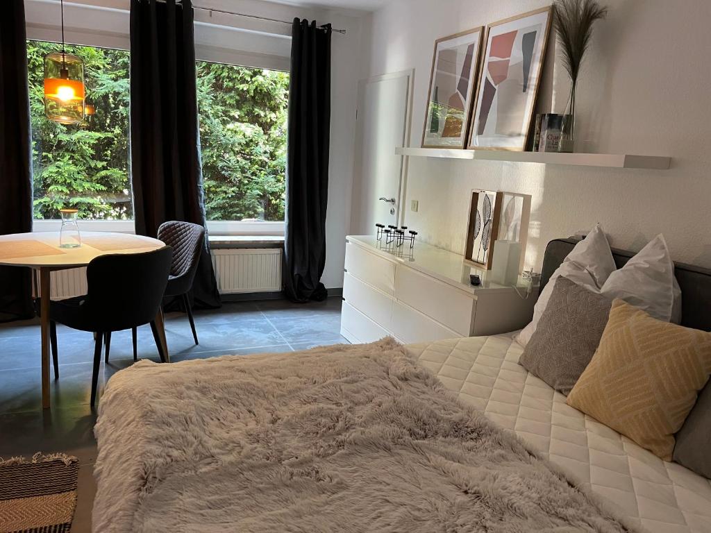 a bedroom with a bed and a table and window at Deich Quartier 9.1 in Dorum Neufeld