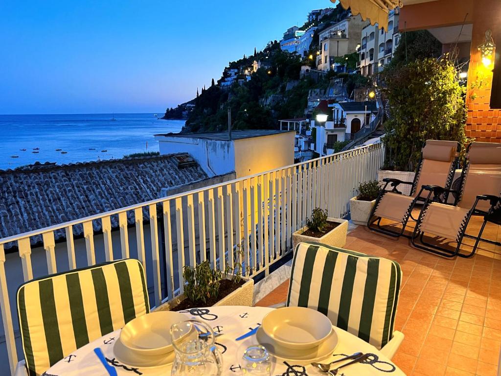 una mesa y sillas en un balcón con vistas al océano en Arco Apartment - Vietri sul Mare, en Vietri