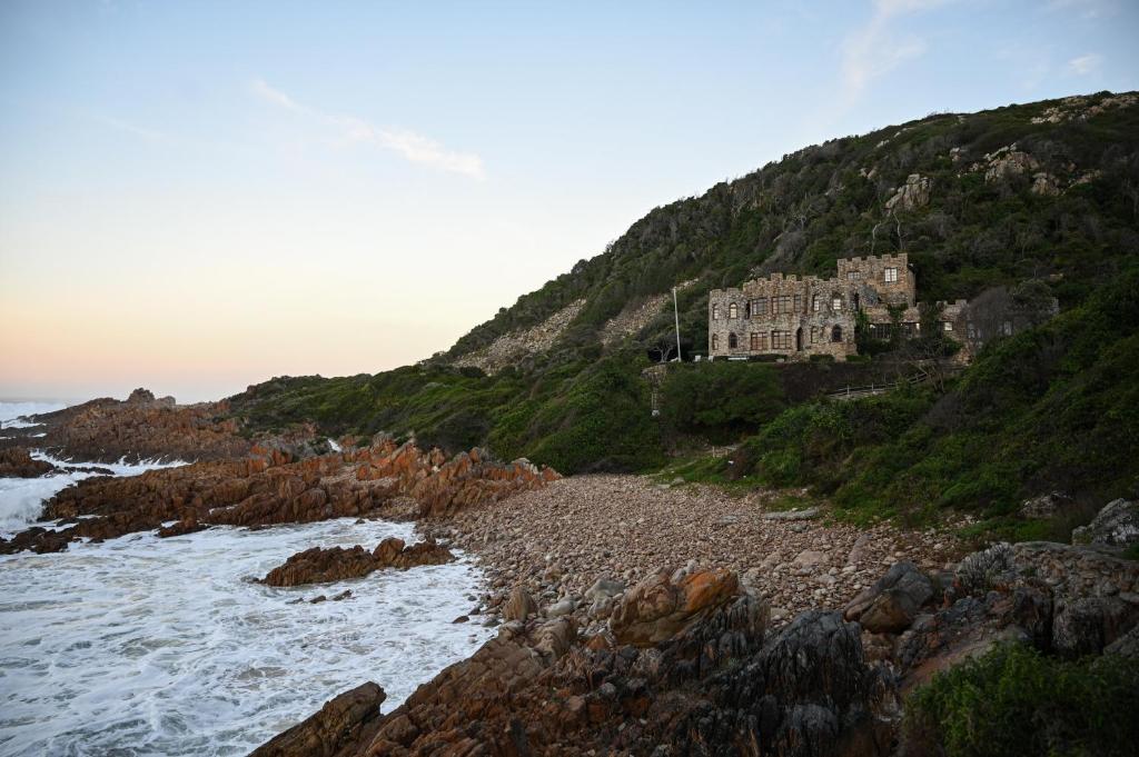 a house on a hill next to the ocean at Buccara Lindsay Castle in Knysna