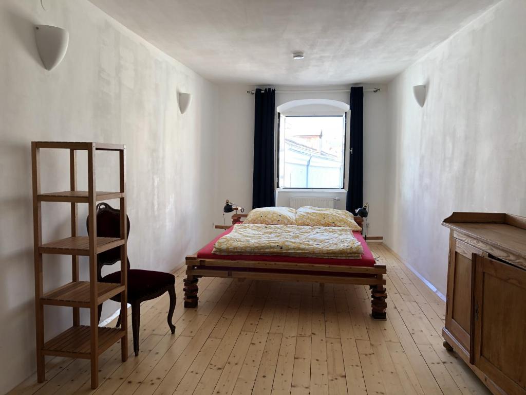 ein Schlafzimmer mit einem Bett, einer Leiter und einem Fenster in der Unterkunft Blick aufs Goldene Dachl in Innsbruck