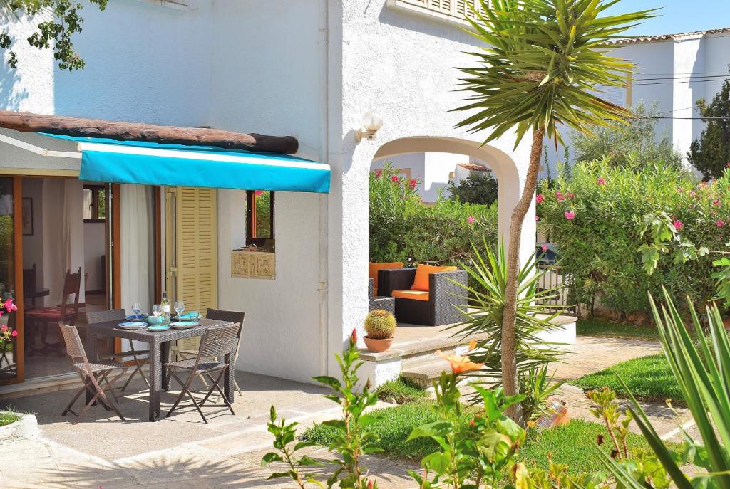 eine Terrasse mit einem Tisch und einem blauen Sonnenschirm in der Unterkunft Casa Esperanza 260 by Mallorca Charme in Playa de Muro