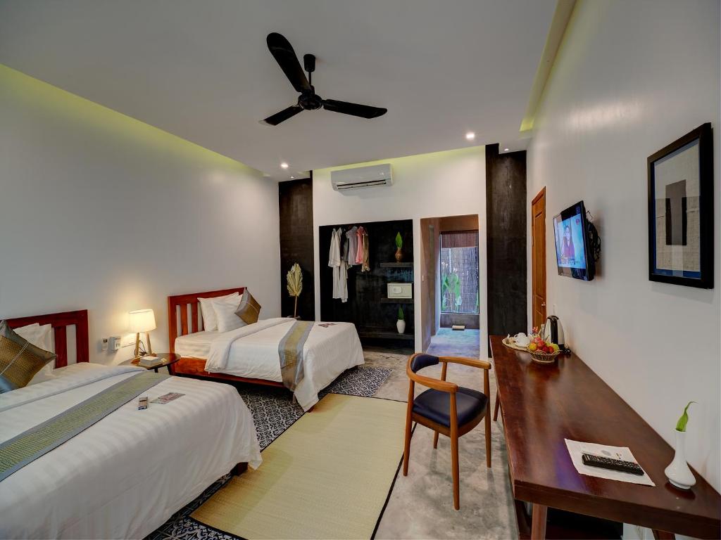 Postel nebo postele na pokoji v ubytování Tanei Angkor Resort and Spa