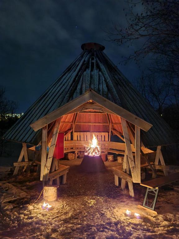 a tent with a fire in it at night at Tromsø Lodge & Camping in Tromsø