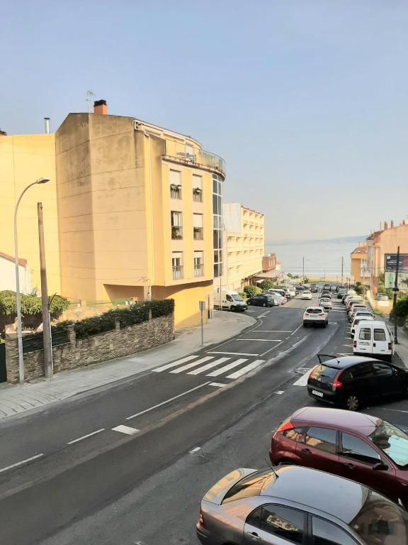 eine Straße mit am Straßenrand geparkt in der Unterkunft Loyos - Playa Grande Miño in Miño