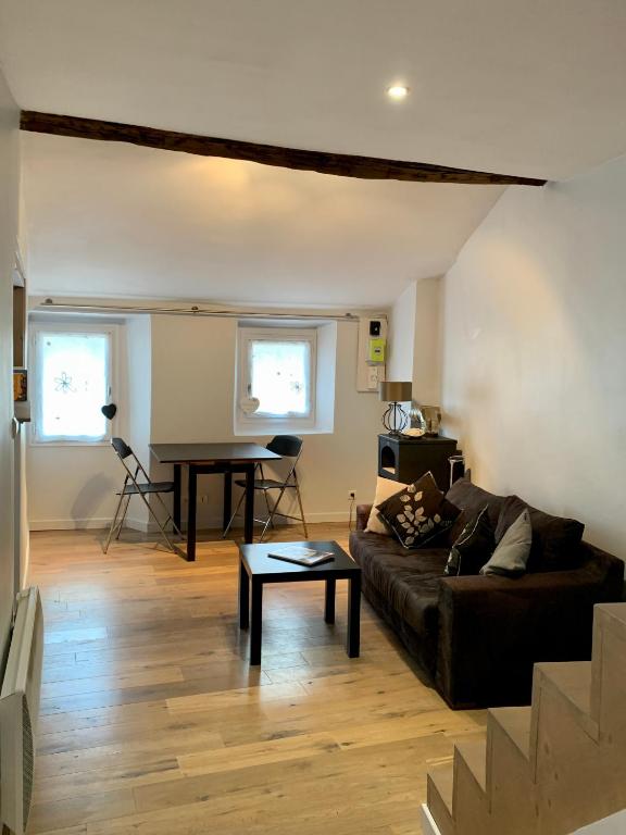 un salon avec un canapé et une table dans l'établissement Le Grenier, à Sospel