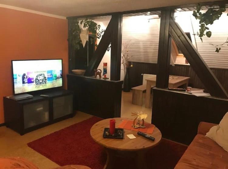 a living room with a television and a table at Gemütliche 3 Raum Wohnung im Dachgeschoss in Ehrenfriedersdorf