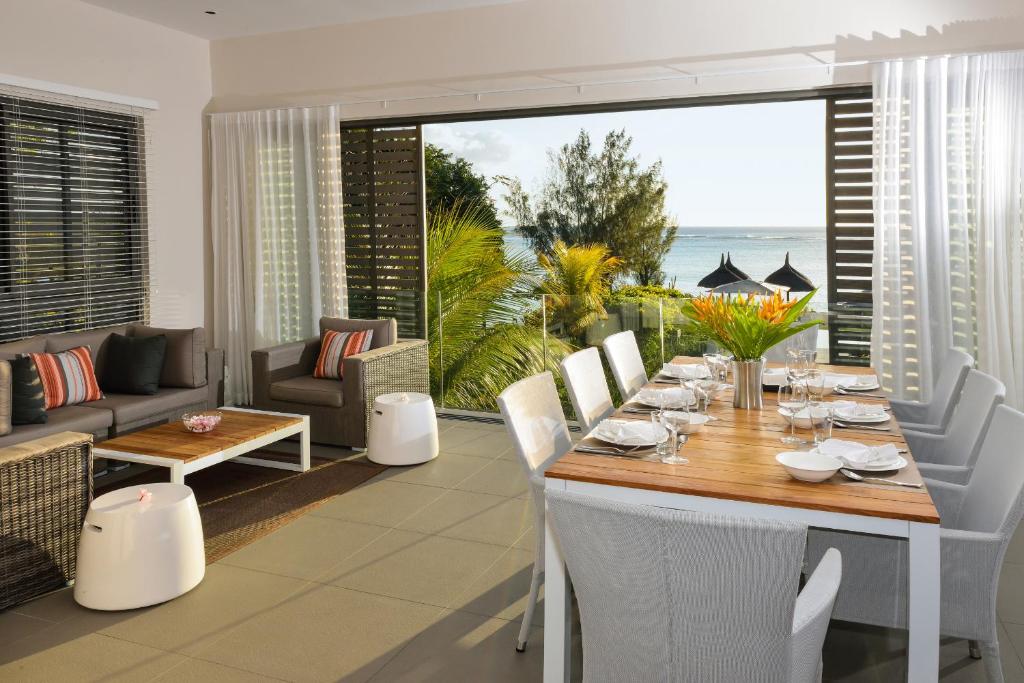 ein Esszimmer mit einem Tisch und Meerblick in der Unterkunft Esplanade by Horizon Holidays in Tamarin