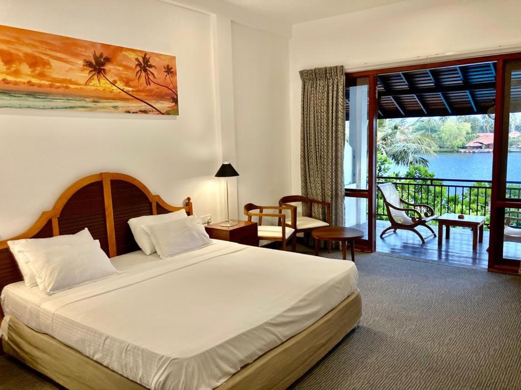 a bedroom with a bed and a view of the ocean at Hotel Nilwala in Bentota