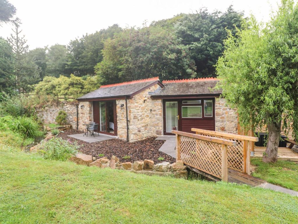 Cabaña de piedra pequeña con porche y terraza en Peony Cottage, en St Austell