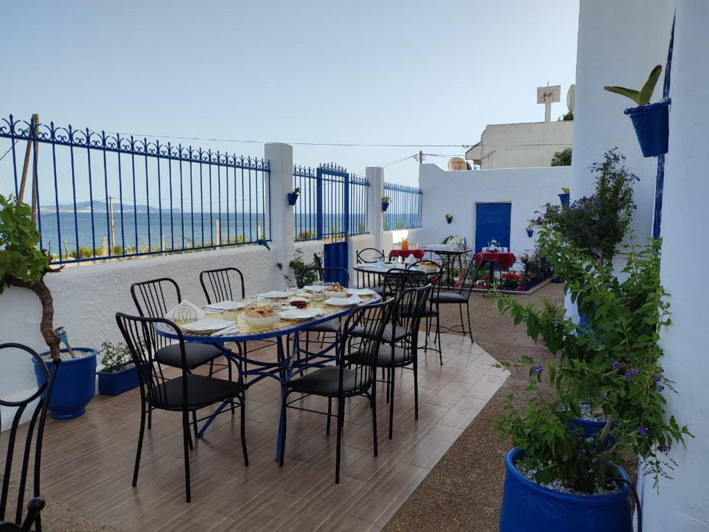 een tafel en stoelen op een balkon met uitzicht op de oceaan bij Maison d'Hôtes Casa Azla in Azla