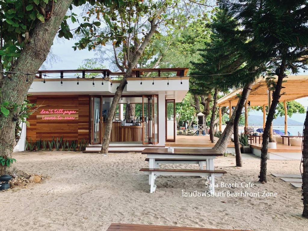 a picnic table in front of a building with trees at Issara Beach Resort Beachfront in Sichon
