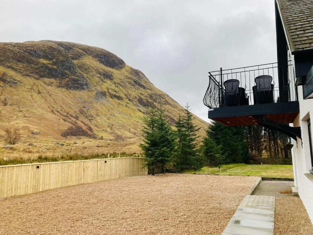 a house with a balcony with a mountain in the background at Achintee Cottages No 2 in Fort William