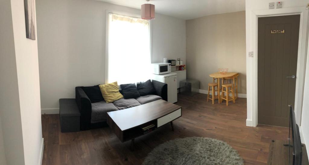 a living room with a couch and a table at Blue house in Lincoln