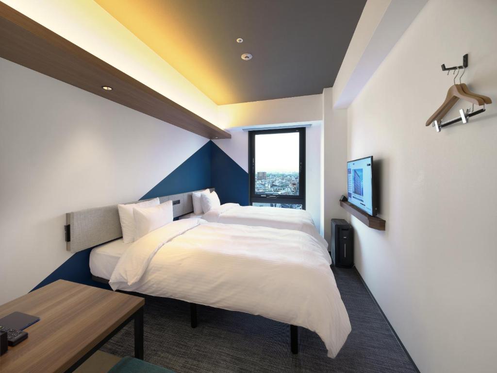 a bedroom with a large white bed and a window at Prince Smart Inn Kyoto Shijo Omiya in Kyoto