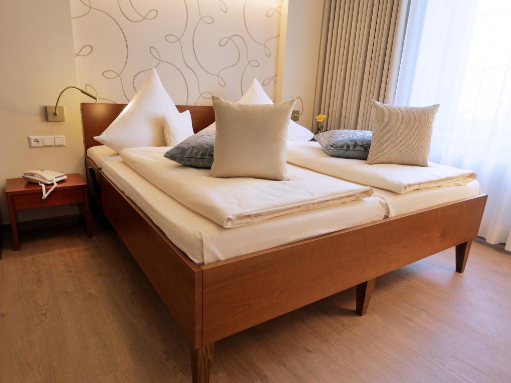1 Schlafzimmer mit 2 Betten und weißen Kissen in der Unterkunft Hotel Martha Dresden in Dresden