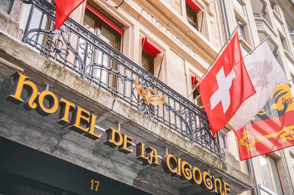 a sign on a building with two flags on it at Hôtel de la Cigogne in Geneva