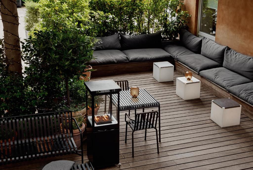 a patio with a couch and some tables and chairs at Avenue Hotel Copenhagen by Brøchner Hotels in Copenhagen