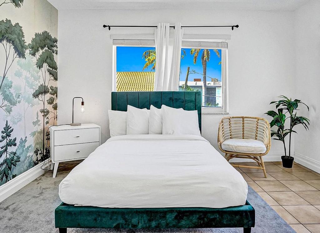 um quarto com uma cama grande e uma cadeira em Walk to Dania Beach Holiday Retreat Miami Pool em Dania Beach