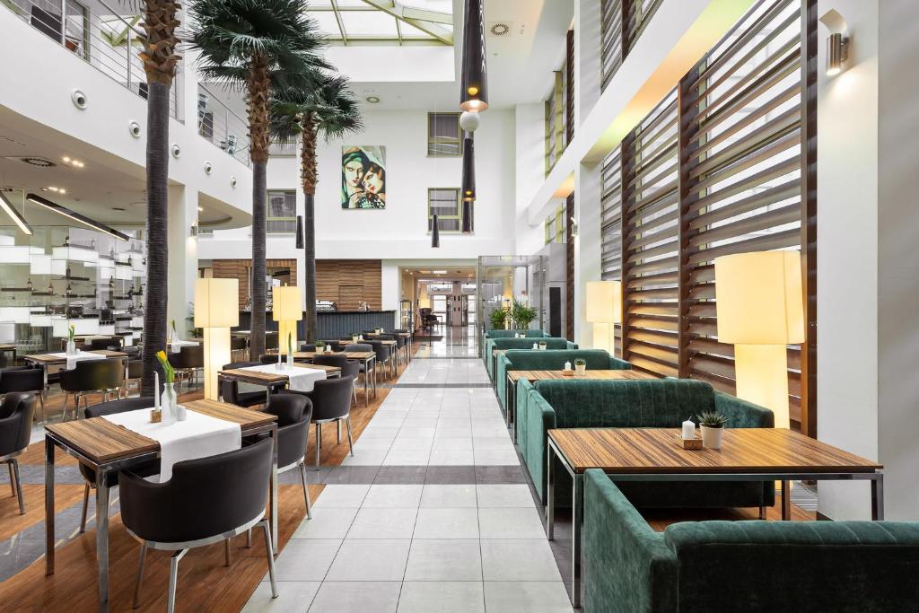 a restaurant with green couches and tables at Hotel Moderno Poznań in Poznań