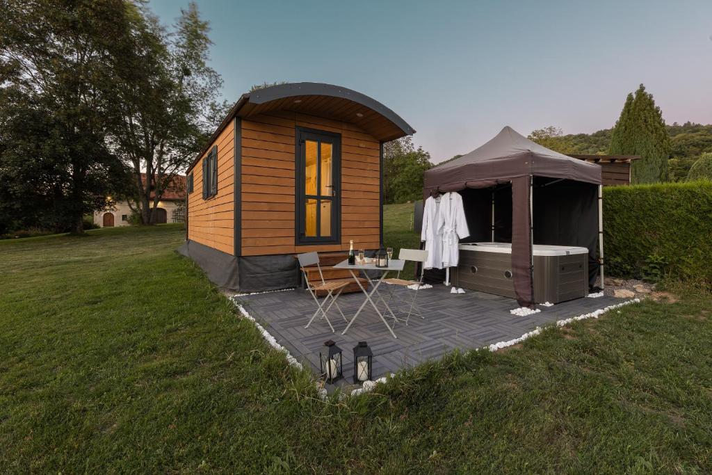 une petite cabine avec une table et une tente dans l'établissement Roulotte Paradis: insolite, SPA privatif, piscine, 