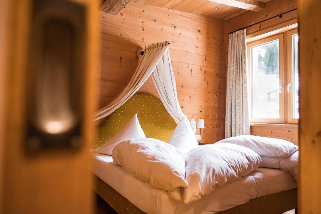a bedroom with a bed with a mosquito net at Vital Chalet Edelweiss in Schröcken