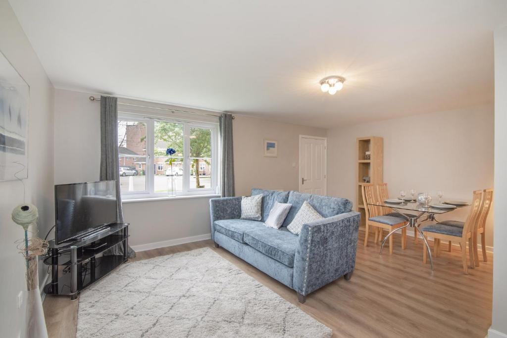 sala de estar con sofá, TV y mesa en The Nelson - Spacious City Property and Free Parking, en Glasgow