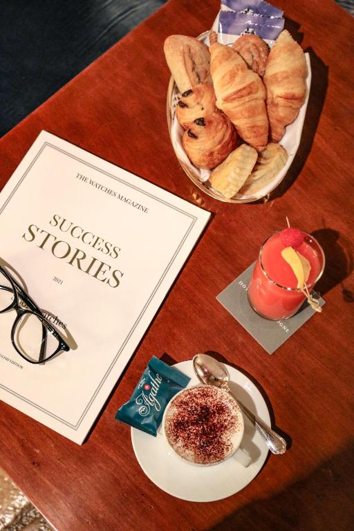 a table with a plate of pastries and a book at Hôtel de la Cigogne in Geneva