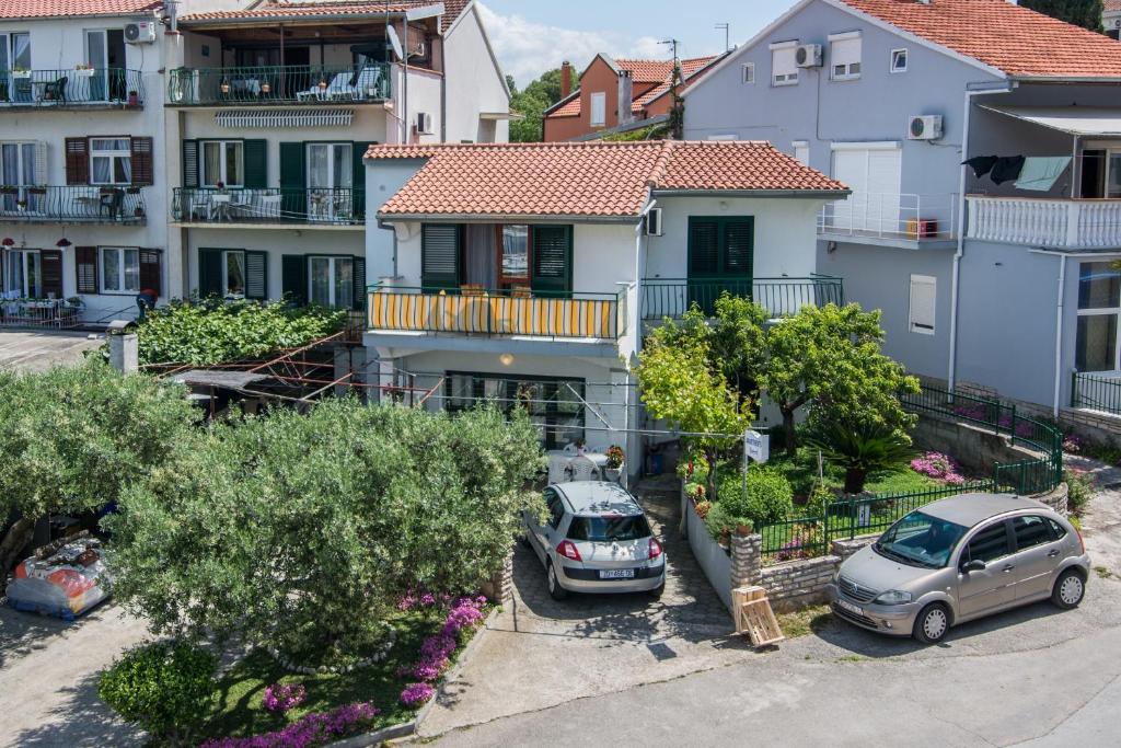 deux voitures garées devant une maison dans l'établissement Apartments by the sea Biograd na Moru, Biograd - 12829, à Biograd na Moru