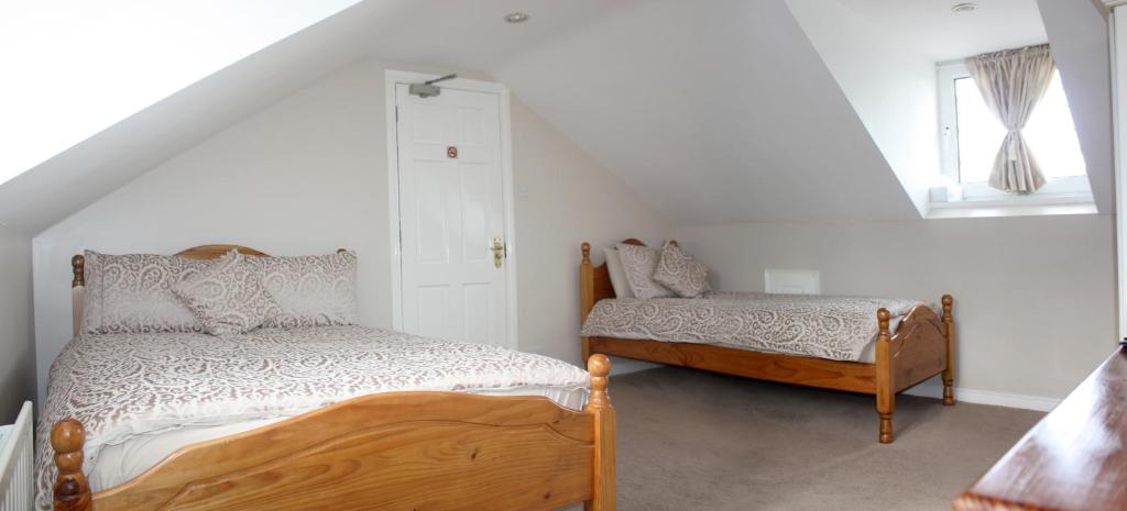 a bedroom with a bed and a bed and a window at Lismore House in Newry