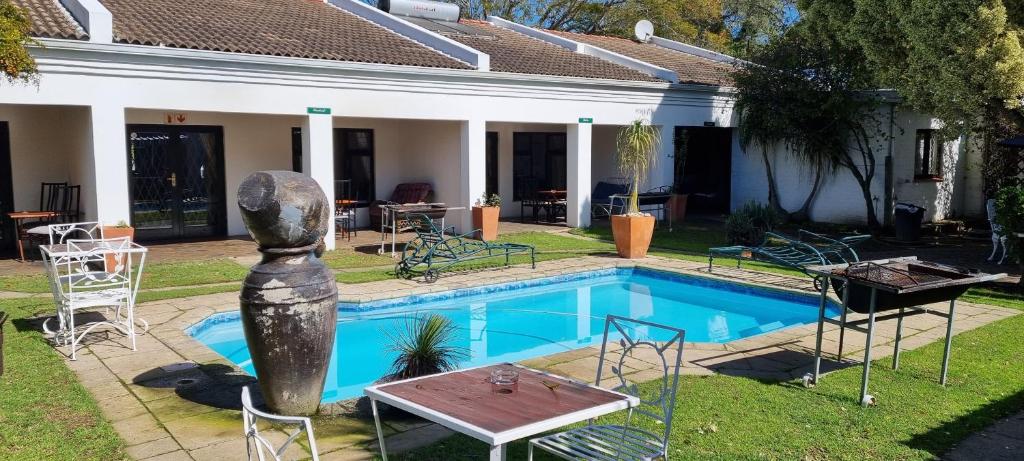 a pool with a statue next to a house at B My Guest in Knysna