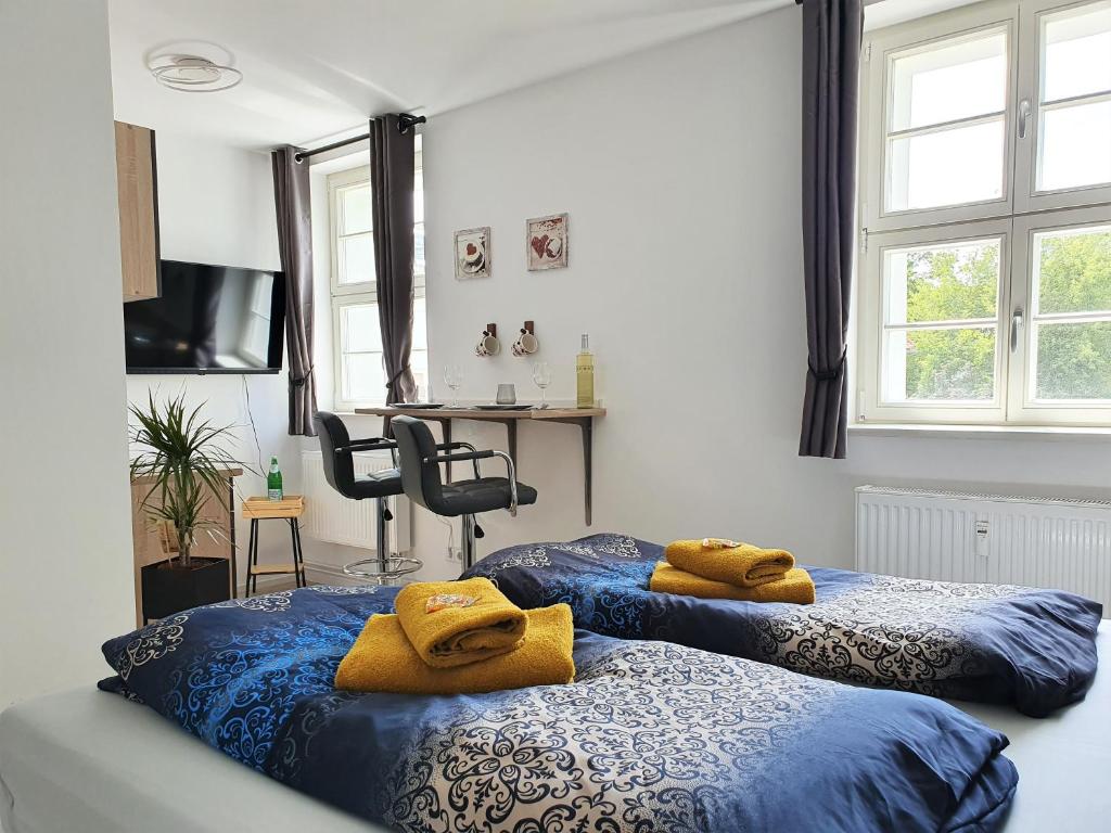 2 Betten mit gelben Handtüchern in einem Schlafzimmer in der Unterkunft "HOGULU" Brandenburg, Im Herzen der Altstadt, Stilvoll, Küche in Brandenburg an der Havel
