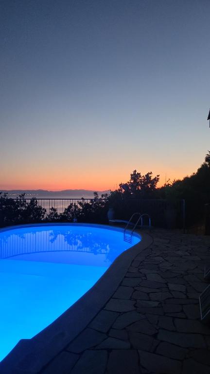 una piscina con tramonto sullo sfondo di Villa panoramica tra suggestive notti stellate. a Torre delle Stelle