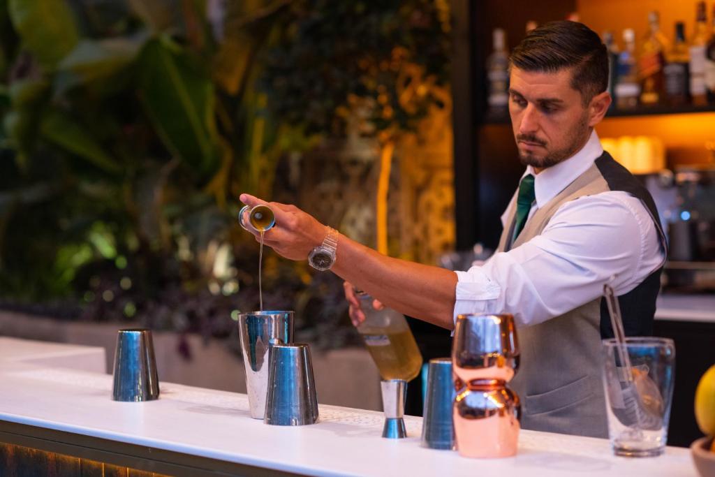 a bartender making a drink at a bar at Valentin Sancti Petri in Chiclana de la Frontera