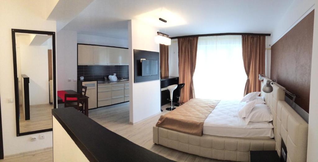 クラヨーヴァにあるExecutive Apartmentsのベッドルーム(ベッド1台、デスク、鏡付)