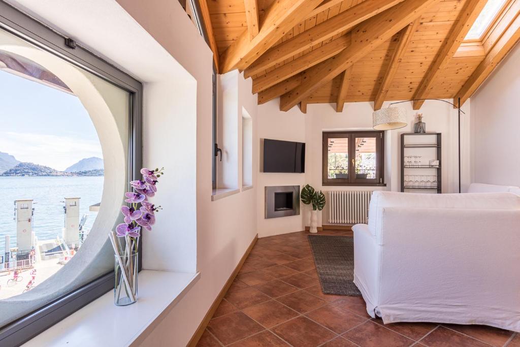 a living room with a white couch and a window at Apartment Tamara Suite - Menaggio in Menaggio